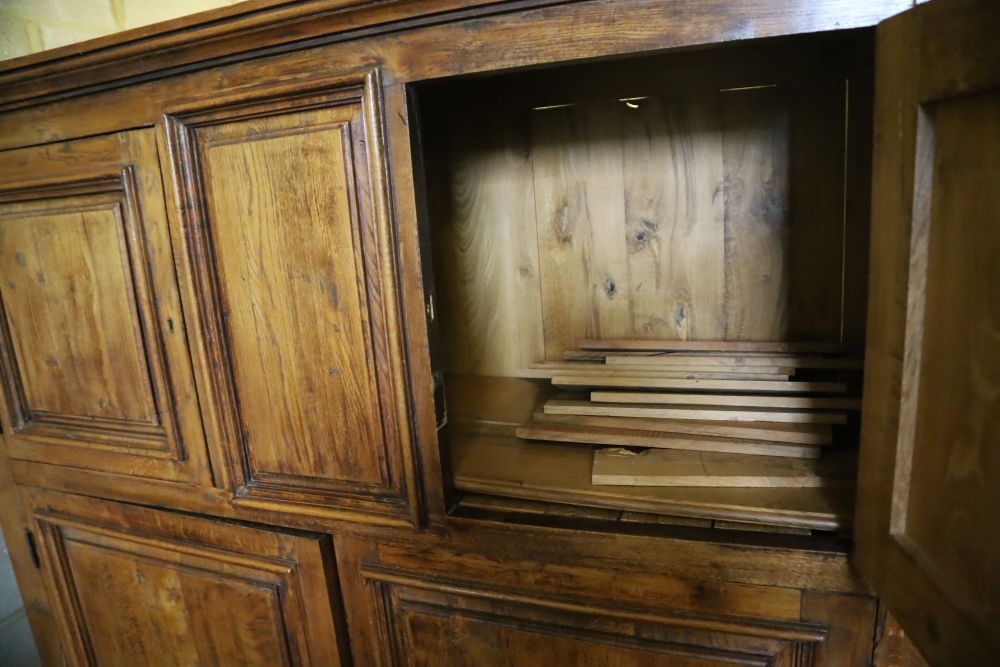 A 19th century French panelled walnut press cupboard fitted upper and lower pairs of doors, width 172cm, depth 52cm, height 181cm